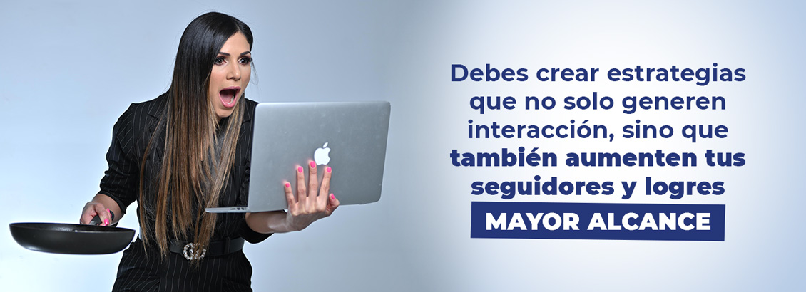 Katy asombrada revisando laptop en una mano y con una sartén en la otra